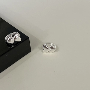 Polished S925 sterling silver hoop earrings with double heart motif on a dark pedestal