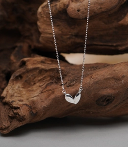 Macro view of polished 925 sterling silver heart pendant on a wooden background