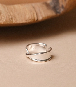 Detail of minimalist 925 sterling silver irregular layered wide ring with glossy finish