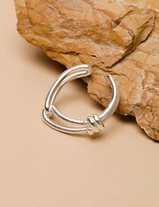 Detail shot of a double-layered knotted S925 sterling silver ring on a stone background