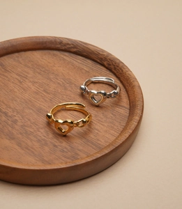 Detailed macro view of S925 sterling silver hollow heart rings on a wooden tray