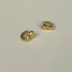 Macro view of gold-plated double heart S925 silver earrings with high-polish finish