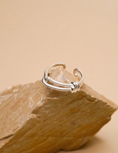 Macro view of double-layer knotted 925 sterling silver ring on natural stone