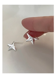 Macro di orecchini a lobo a stella in argento 925 tenuti tra le dita della mano