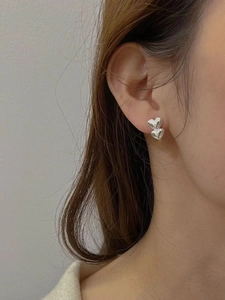 Close-up of elegant double stacked heart stud earrings in polished S925 sterling silver