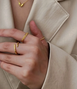 Macro shot of 925 silver gold-plated heart pendant and stacking rings jewelry set