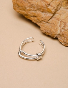 Close-up of a double-layer silver knot ring with snake chain texture and open design