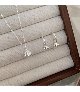 Detailed view of polished silver water drop necklace and earrings in a premium jewelry box