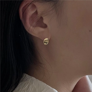 Boucles d'oreilles ovales dorées polies pour femmes, portées pour un style minimaliste