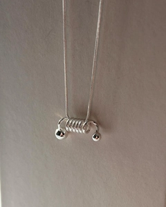 Macro shot of 925 silver spring spiral pendant and fine snake chain texture