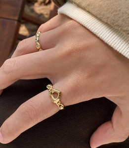 Detail of stacked gold S925 silver rings featuring heart shape and hammered texture design