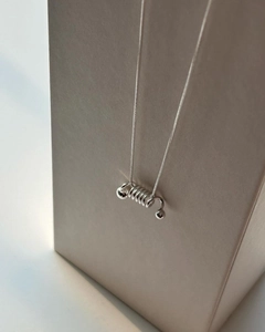 Close-up of a 925 sterling silver spring spiral pendant on a sleek snake chain