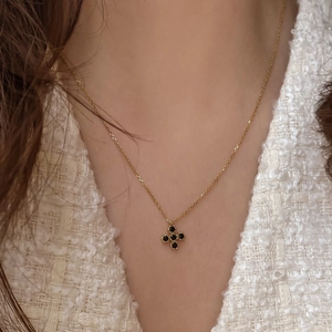 925 silver gold necklace with black clover pendant worn on a model with white tweed jacket