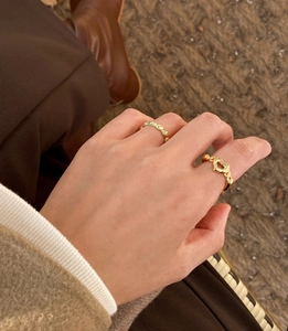 Detail of S925 sterling silver gold heart ring and wavy band on model fingers
