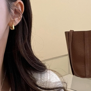 Minimalist gold U-shaped geometric earrings worn by a model for a stylish modern look