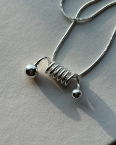 Macro shot of 925 silver spiral spring pendant with sleek snake chain texture