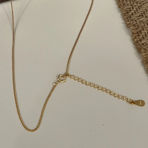 Macro detail of 925 sterling silver S925 hallmark stamp and spring ring clasp on gold chain
