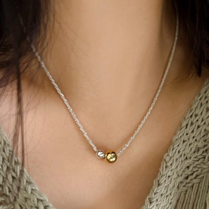 Sparkling silver textured chain necklace with gold and silver dual-tone beads on model