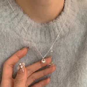 Minimalist S925 sterling silver necklace with ball and oval pendant on female model
