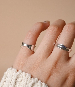 Close-up of irregular wavy 925 sterling silver rings worn on hand for women