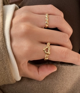 Detail of adjustable gold S925 silver heart ring and beaded band set on model hand