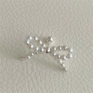 Macro shot of 925 silver pearl bow stud earring with threaded screw back on leather