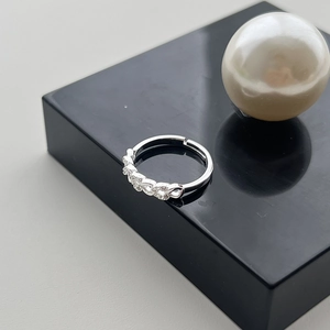 Close-up of adjustable silver ring featuring five sparkling round-cut cubic zirconia stones
