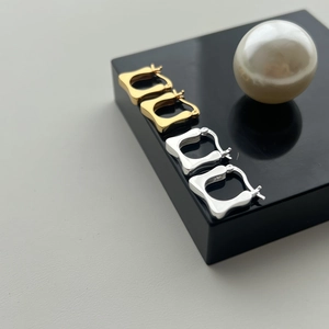 Macro shot of S925 sterling silver stamp on minimalist square geometric earrings