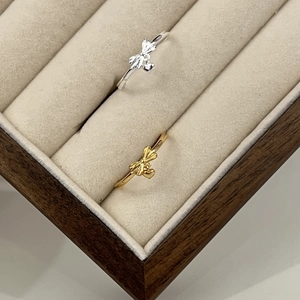 Detailed shot of gold and silver bow rings with heart pendants in a velvet jewelry box