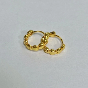 Detailed close-up of golden heart chain earrings featuring a 3D linked heart pattern