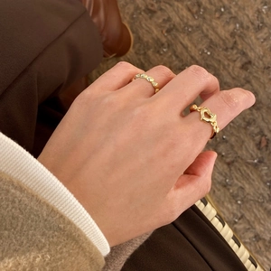 Elegant gold-plated open heart rings with textured bands on model's hand