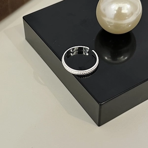Minimalist S925 sterling silver open ring with twisted texture displayed on black stand