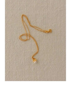Détail du pendentif nœud en argent 925 avec perle blanche sur une chaîne dorée