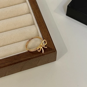 Elegant gold 925 sterling silver bow ring with adjustable open band on wood display