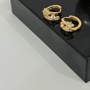 Macro detail of gold-plated 925 sterling silver star earrings with white zircon stones