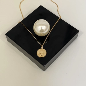 French vintage 1974 gold coin necklace with Liberty relief on a sleek display stand