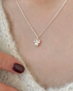 Détail d'un collier en argent 925 avec pendentif nœud et perle sur un mannequin
