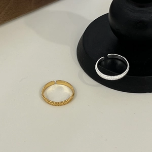 Macro detail of gold and silver S925 rings featuring a unique beaded texture design