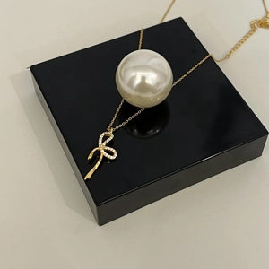 Dettaglio della collana in argento 925 dorato con ciondolo a fiocco e strass incastonati