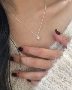Vue détaillée du collier avec pendentif nœud en argent 925 et perle sur la clavicule