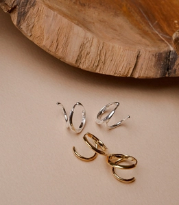 Macro shot of silver and gold S925 sterling silver triple layer spiral hoop earrings