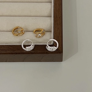 Detail of gold and silver sterling silver hoop earrings with sparkling zircon inlay