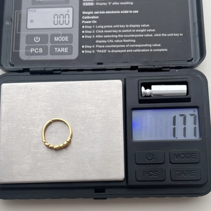 Macro shot showing 1.77g weight of gold wave pattern ring on a digital scale