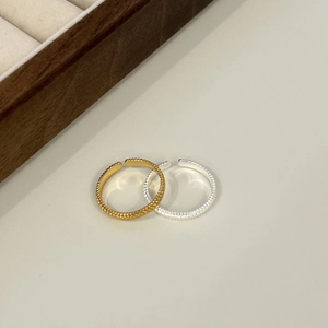 Detail of adjustable S925 silver rings with unique granular texture in gold and silver