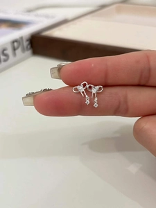 Vue macro détaillée des boucles d'oreilles nœud en argent S925 avec cristaux brillants