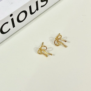 Detailed view of elegant gold bow earrings featuring a sleek and minimalist design