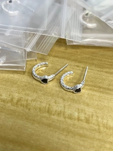 Detailed macro view of S925 sterling silver hoop earrings with black heart-shaped stone