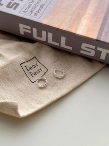 Macro detail of S925 sterling silver hoop earrings with textured beaded pattern