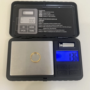 Detailed view of textured S925 silver ring in gold finish weighing 1.36g on electronic scale