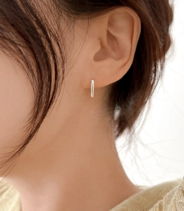 Gros plan de boucles d'oreilles créoles géométriques en argent sur le mannequin